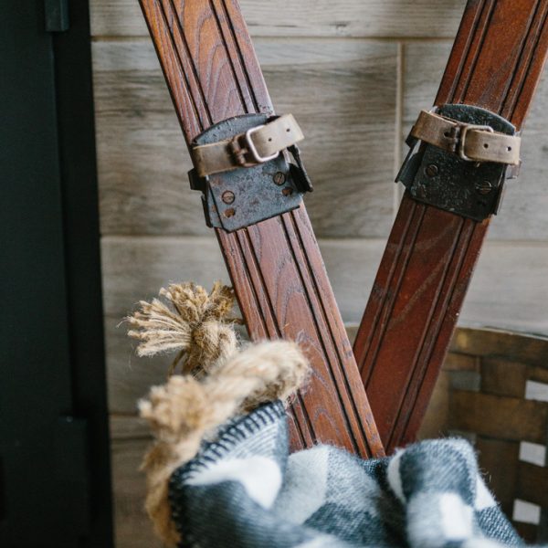 Antique Skis in a Basket With a Plaid Blanket